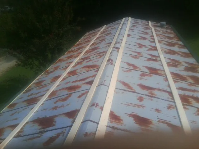 Rusted metal roof panels with new wood purlins before replacement — Storm Damage Roof Repair in Semora by Roofing Brothers