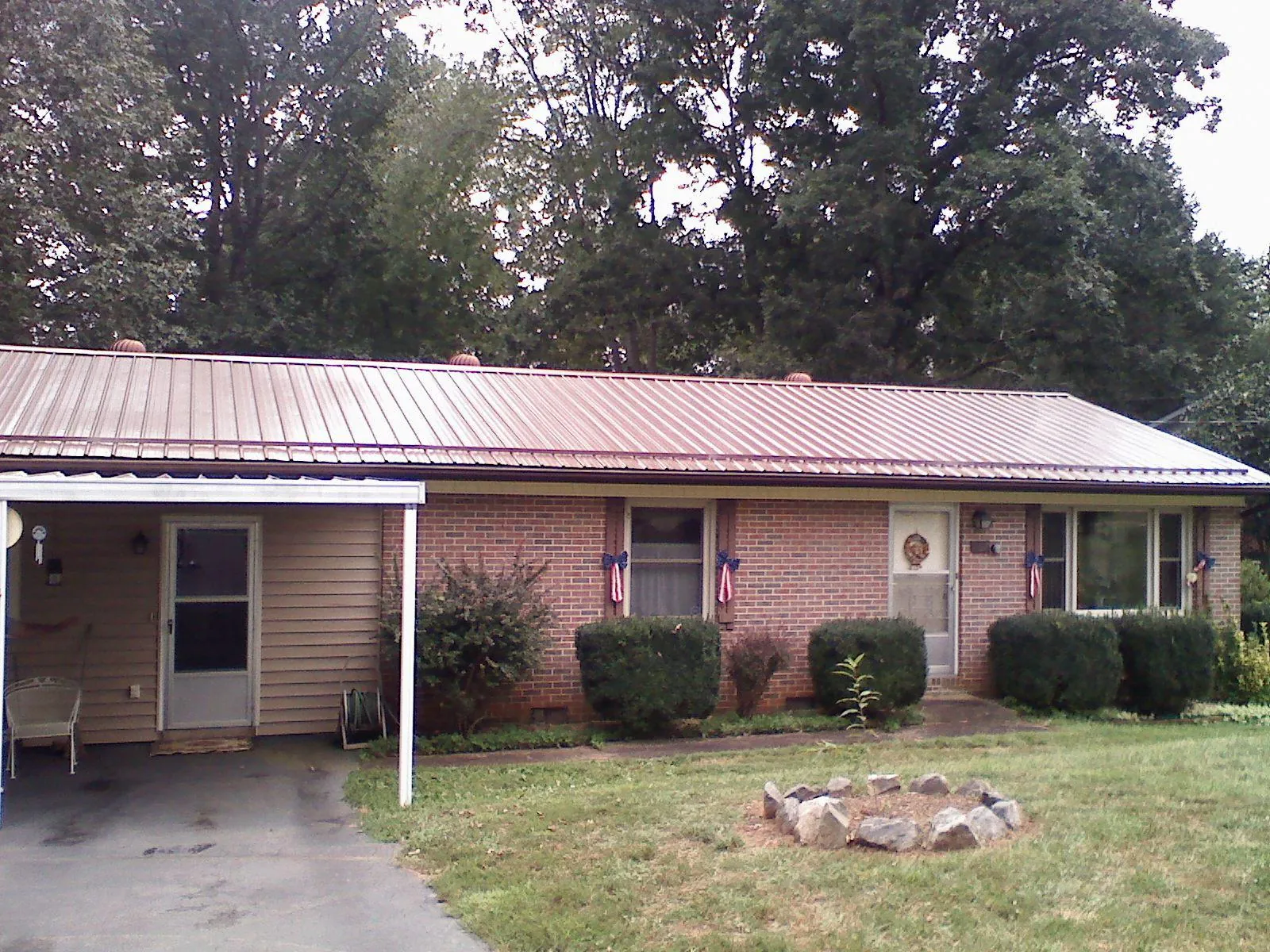 Bronze metal roof and carport on a brick ranch home — Roof Repair work by our crew in Semora