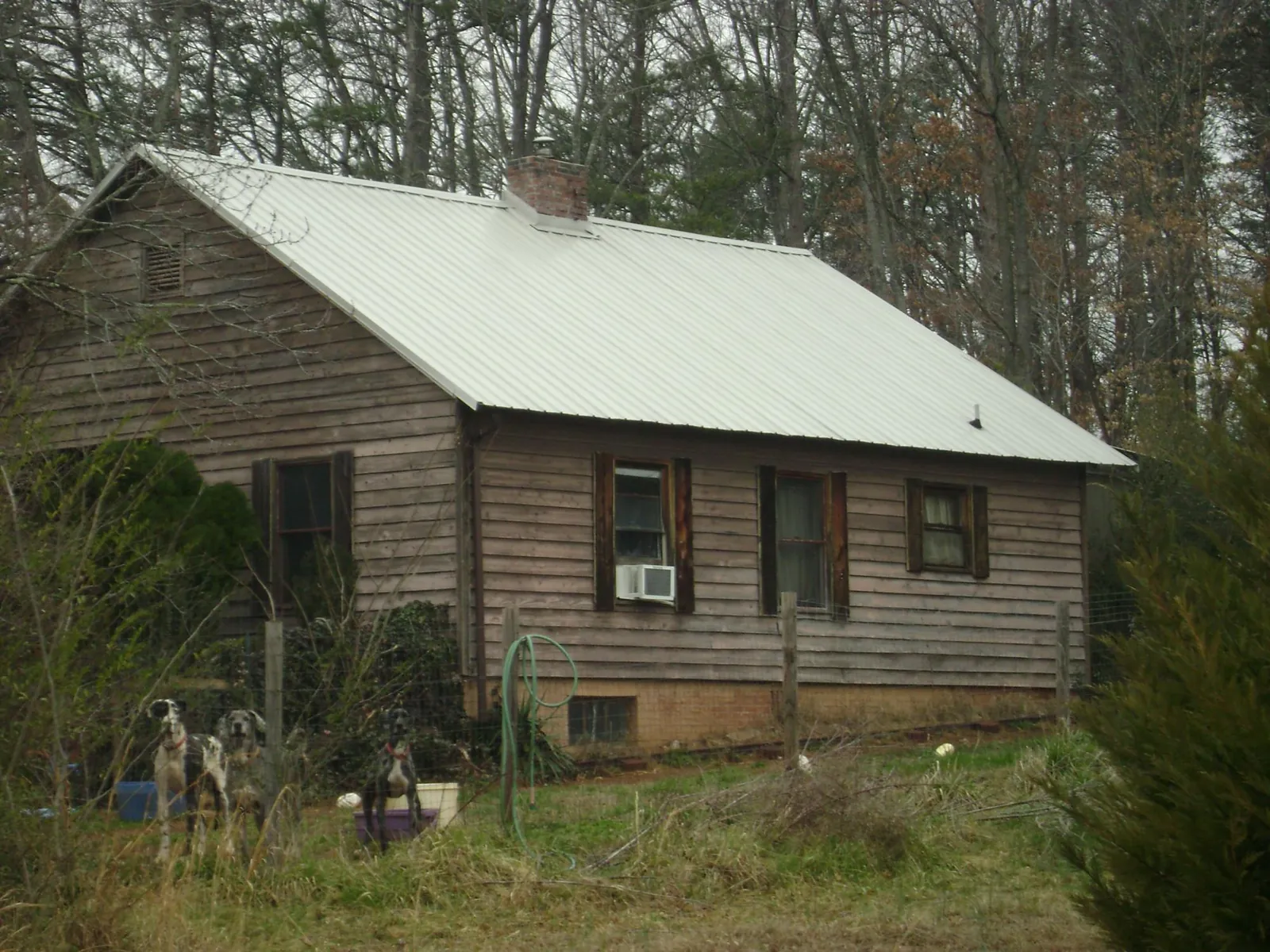 White metal roof on an old wood sided farmhouse, from a Metal Roof Installation job in Semora